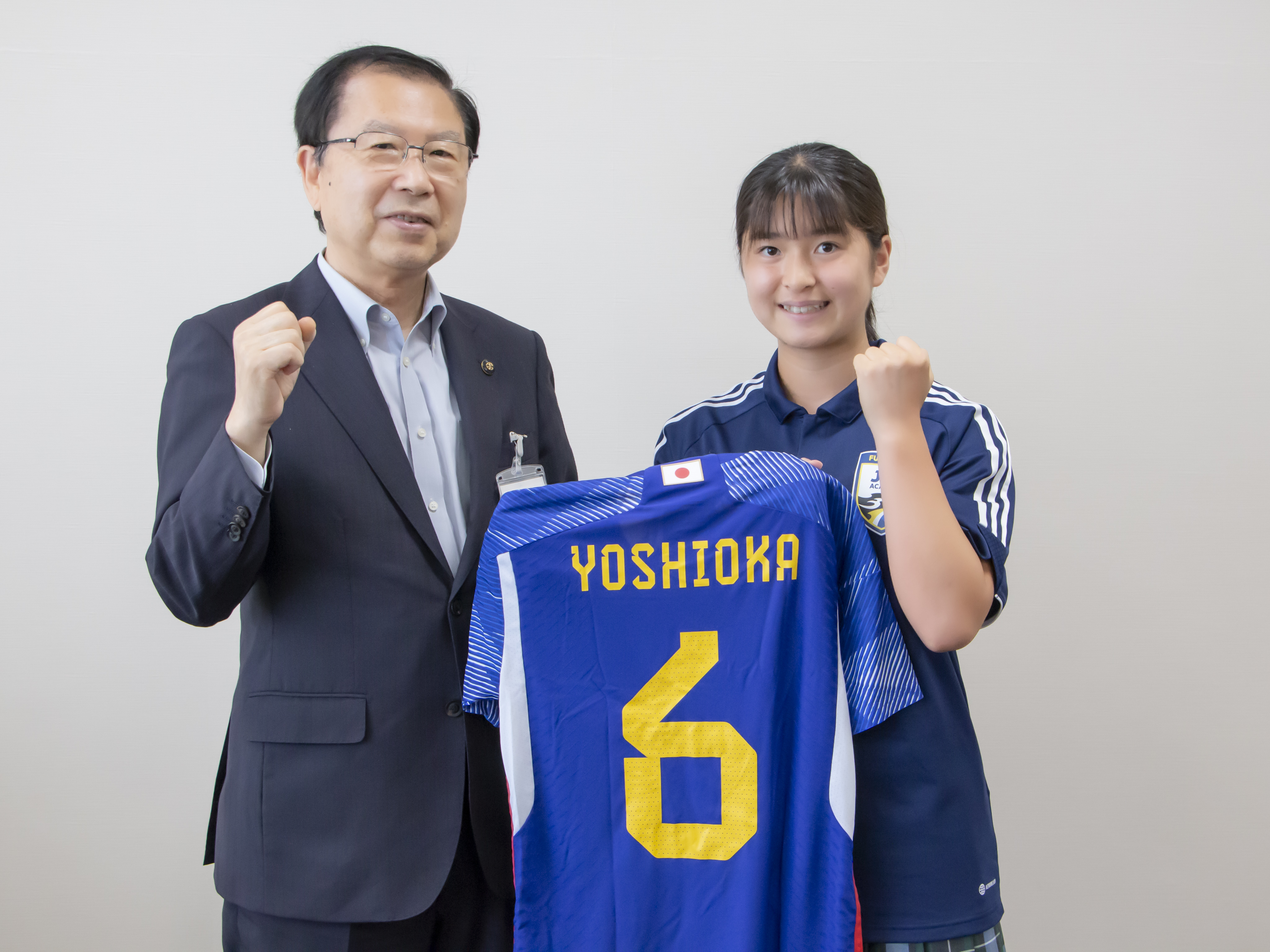 日本代表のユニフォームを持って市長と記念撮影する吉岡選手