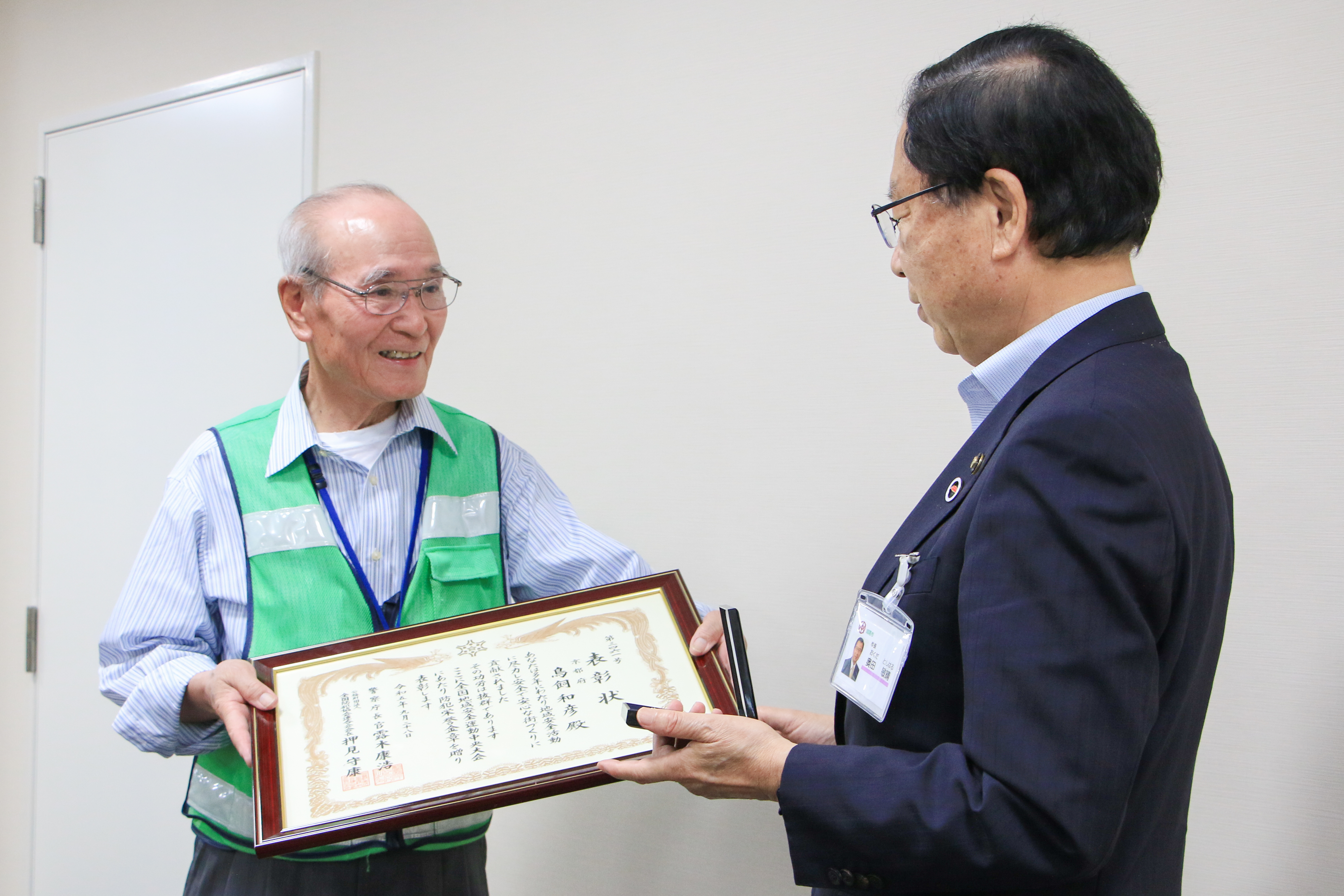 受賞した賞状を市長に見せる鳥飼会長