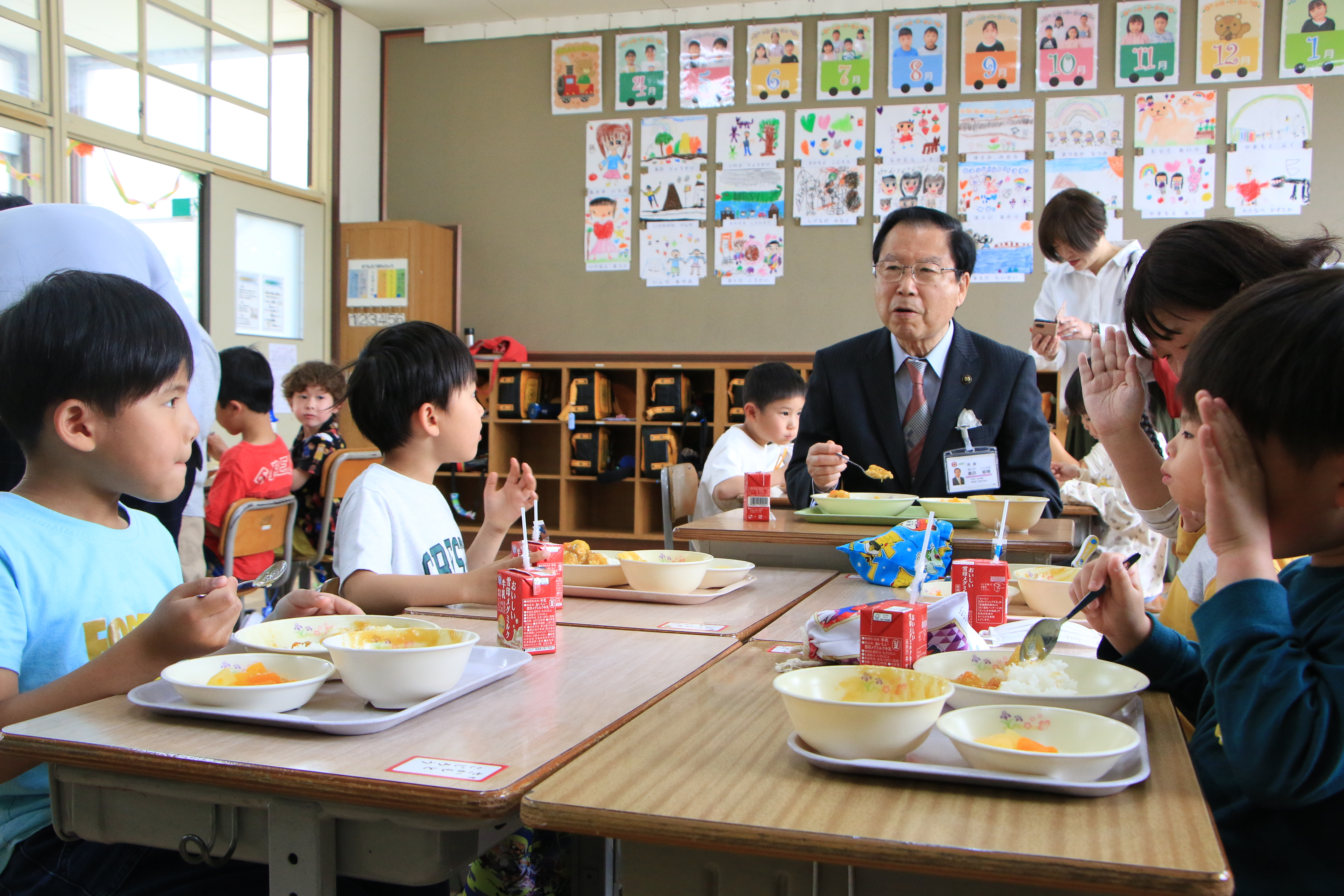深谷小学校の新1年生と給食を食べる市長